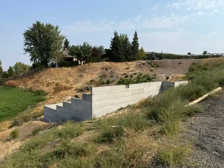 Stepped concrete block retaining wall seen from below the slope