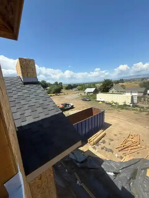 View along a new shingled roofline from the ridge with the yard below