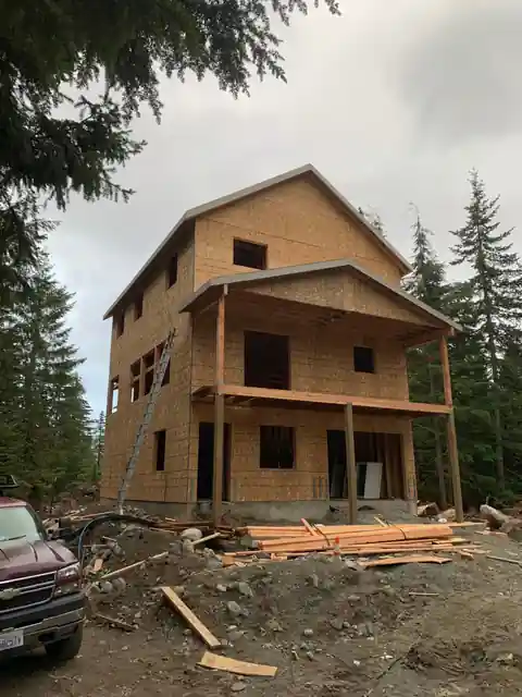 Three-storey framed house standing among tall firs in Snoqualmie